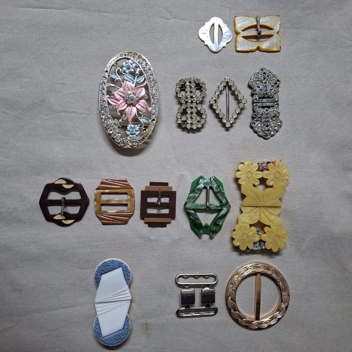 14 Vintage belt buckles - mother of pearl, glass, bakelite, and metal in vintage tin