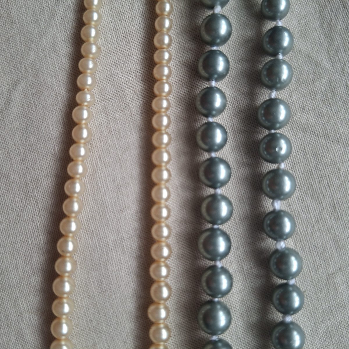 2 vintage faux pearl necklaces 1 grey and 1 cream.  1 is knotted.