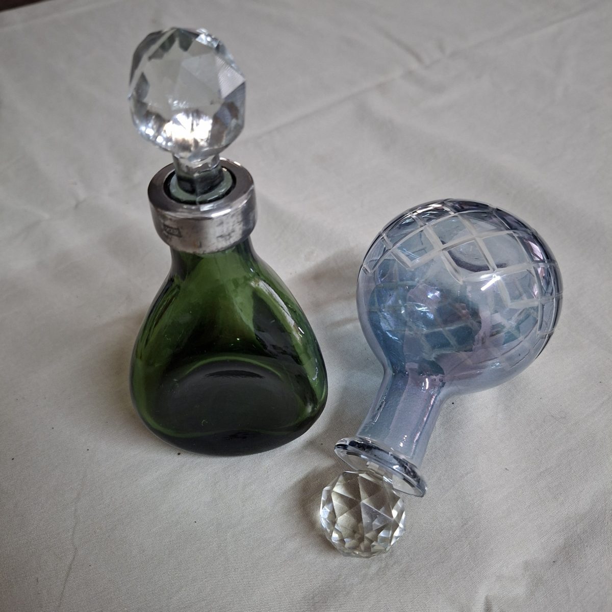 2 glass perfume decanter bottles approx 16 cms tall - stamped gero. Cut crystal stoppers