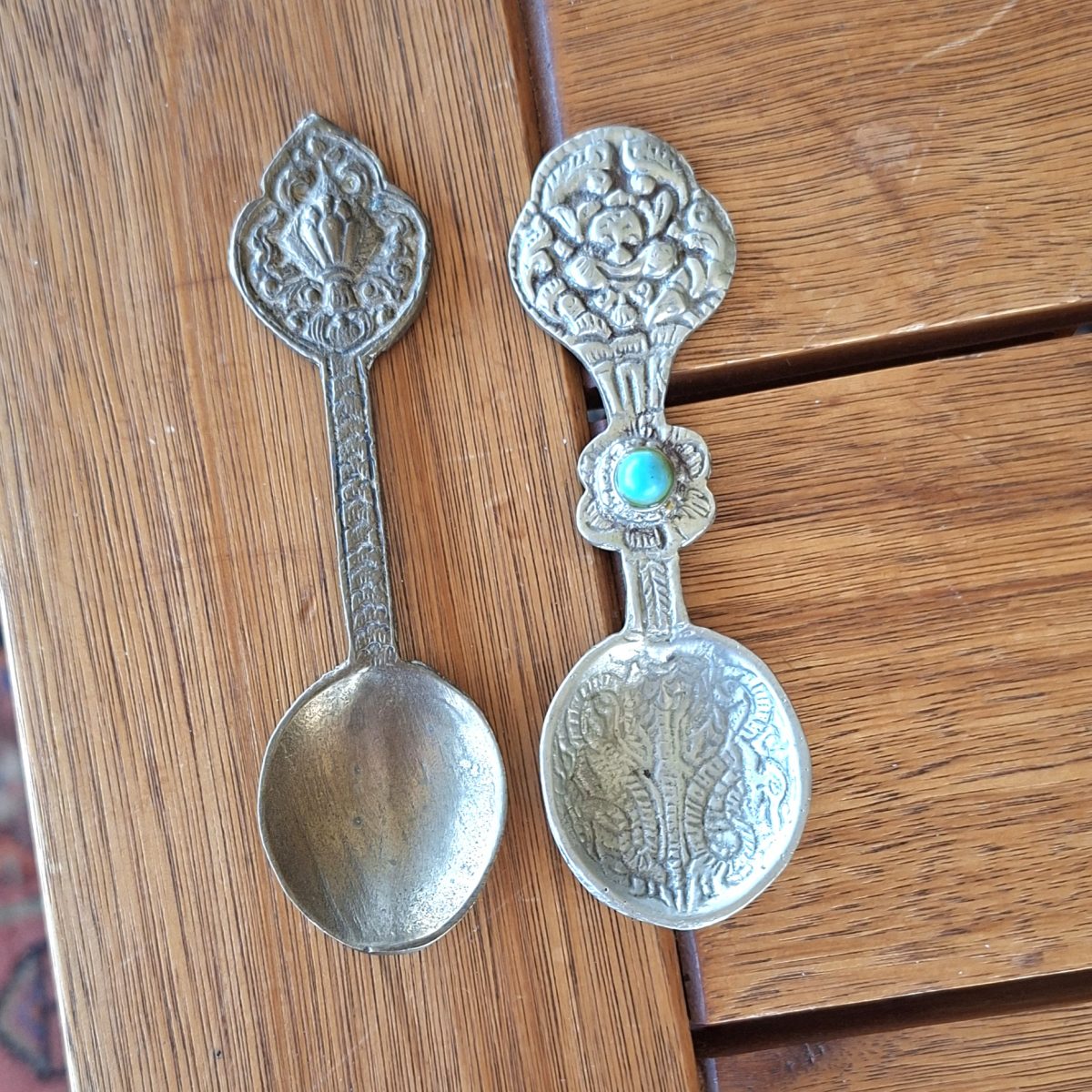 2 Eastern indonesian? metal teaspoons one with a blue "stone"  aprox 11.5 cms each