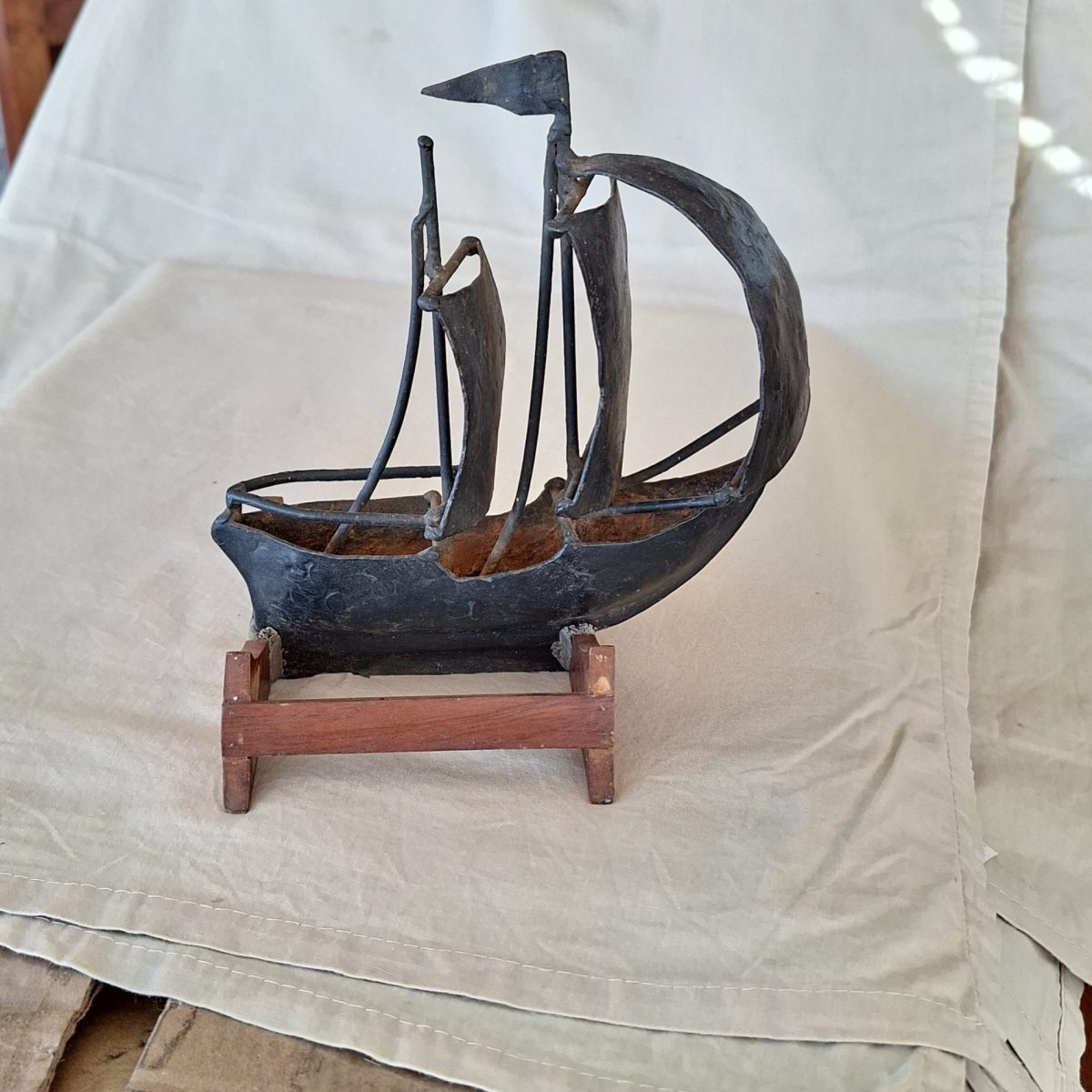 Metal sailing ship - hand crafted metal ornament on wooden base.
