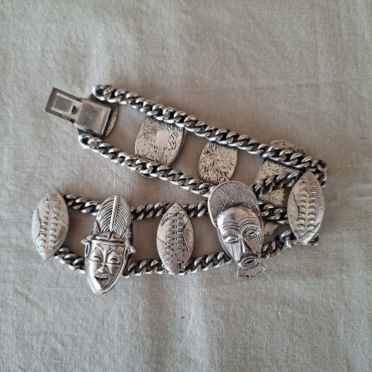 Silver metal bracelet - heavy tribal theme masks and shields