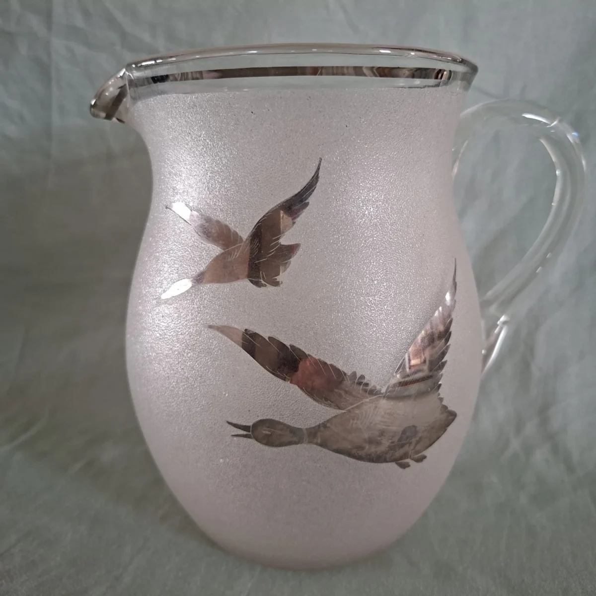 Water jug with silver flying ducks overlay.   Handmade heavy glass. Lemonade jug