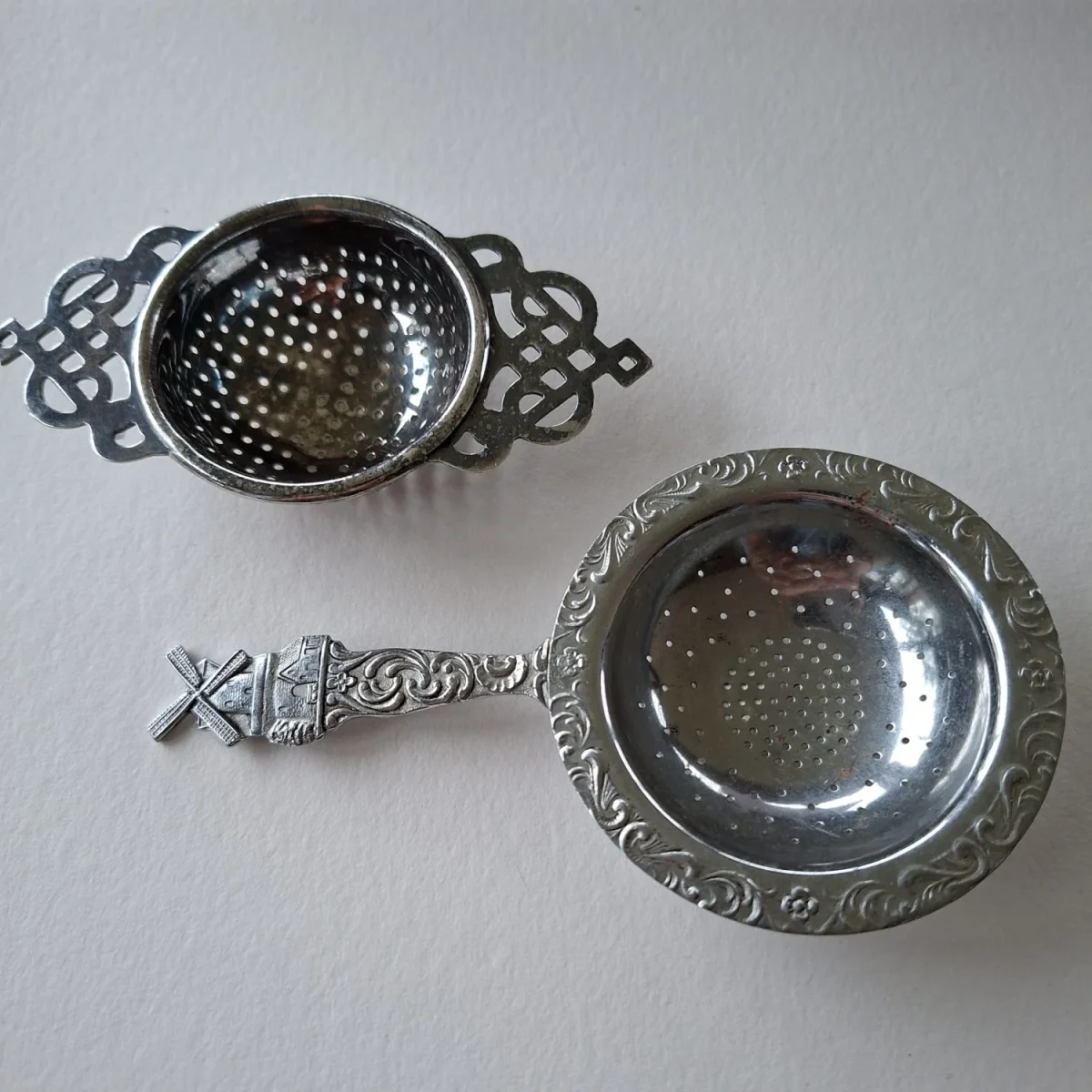 2 silver metal tea strainers 1 with windmill other made in UK